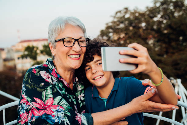 istock Boy and his grandma riding on a carousel and taking a selfie 1214058811