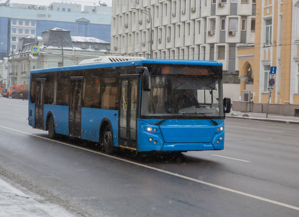 istock bus moves in winter in snowfall on a city 1214058828