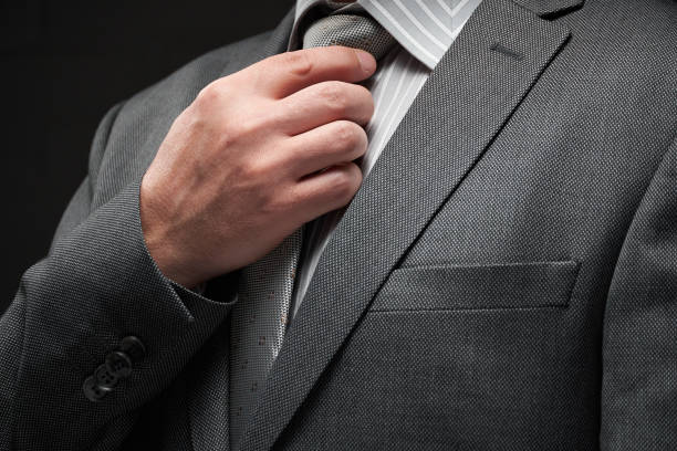 istock businessman portrait dressed in gray suit, dark wall background 1214059501