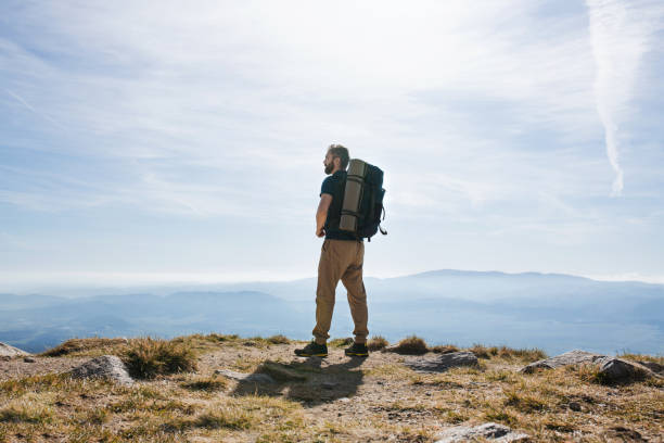 istock Rear view of man with backpack hiking in mountains in summer. 1214060470