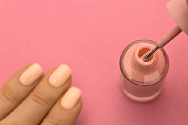 istock Pink nail polish with brush on pink background 1214060602