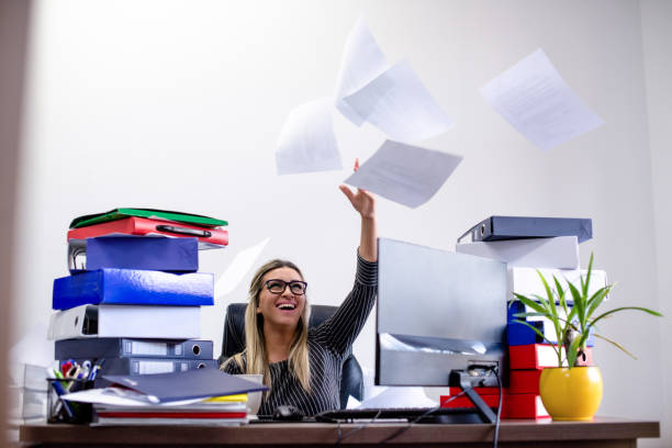 istock Businesswoman throws papers in office 1214061029