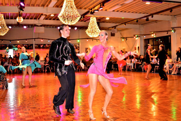 Couples Latin dancing Demonstration. Herent, Belgium - September 14, 2019: Open House indoor dancing classes evening show. International Latin competition Dancers  demonstration. In background one  of couple ladies is a wheelchair dancer. chandelier earring stock pictures, royalty-free photos & images