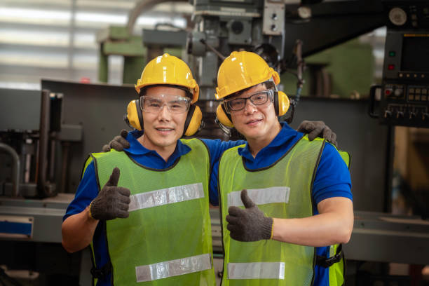 istock Professional technicians and engineers wearing protective clothing showing thumbs up. Technician in the industry at machine maintenance working congratulation. 1214061881