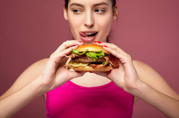 istock Hungry woman holding big burger. 1214063103
