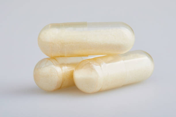 прозрачные желатиновые капсулы с цинковым порошком на белом фоне - chinese medicine herb pill nutritional supplement стоковые фото и изображения