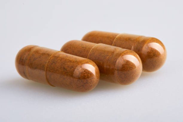 白い背景に白い背景にダイスペーパーパウダーと透明ゼラチンカプセル - chinese medicine nutritional supplement herb pill ストックフォトと画像