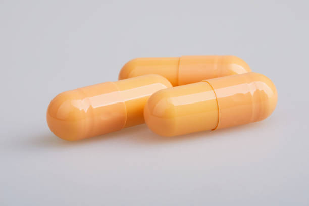 istock Orange gelatin capsules with powder, isolated on white background 1214063420