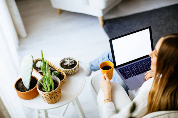 istock Happy smiling woman sitting on sofa and using laptop 1214064791