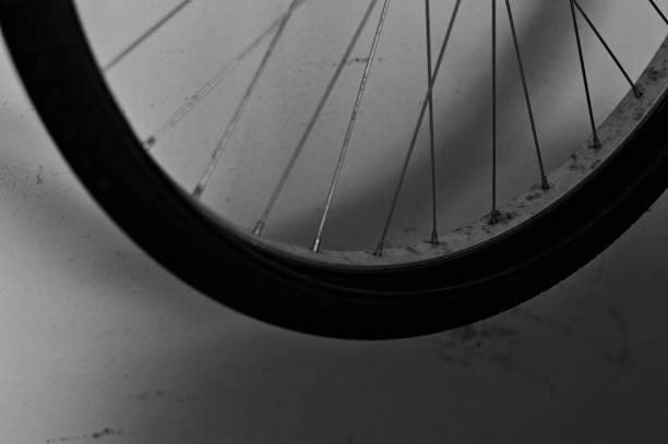 bicycle wheel against a dirty wall in the garage (pesaro, italy, europe) - bicycle chain bicycle tire black and white imagens e fotografias de stock