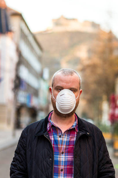istock Man wearing protective face mask outdoors on city street 1214067686