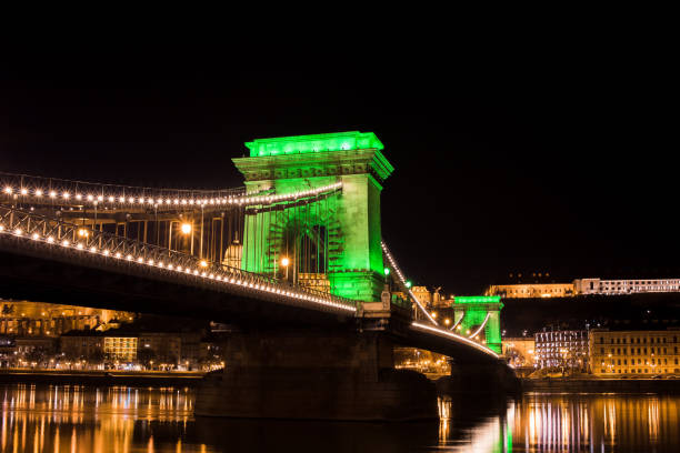 pont de chaîne avec des lumières vertes le jour de saint patrick à budapest la nuit. - budapest chain bridge night hungary photos et images de collection