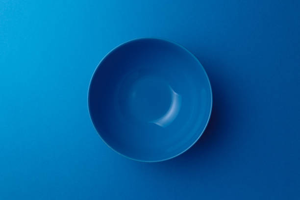 istock Empty ceramic blue round plate on classic blue background. Top view. Flat lay. Copy space. Minimal creative concept. Trendy color 1214068779