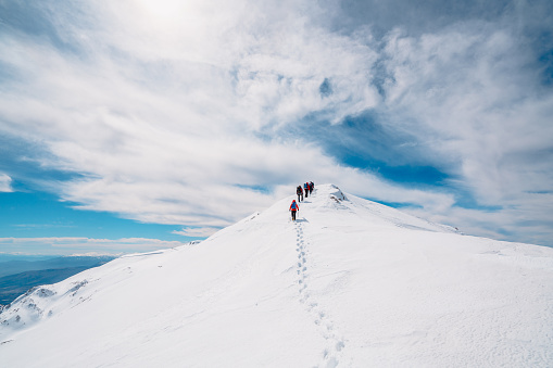 Equipo de escalada alpina de montaña que se mueve en una fila en pico de montaña de gran altitud en invierno photo