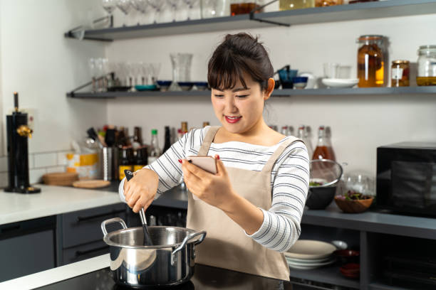 istock Housewife cooking while watching the menu recipe 1214071289
