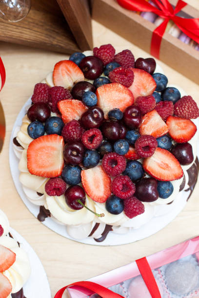 Pavlova cake with fresh strawberries, cherries, blueberries and raspberries.