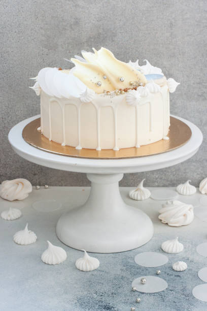 istock Elegant white wedding cake with chocolate decoration, meringues and macaroons. 1214072169