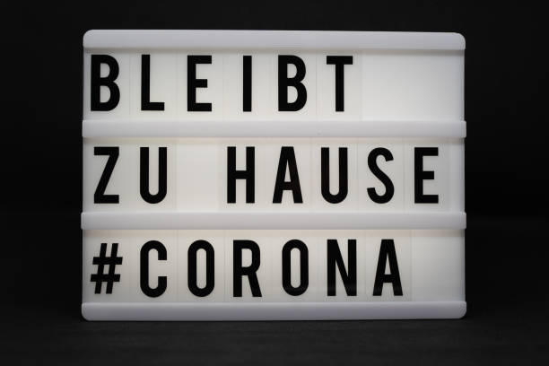 istock is written on an illuminated panel with black letters: Stay at home #Corona 1214072774