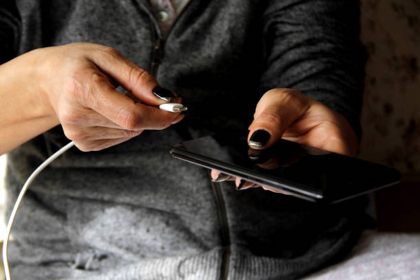 istock Woman hands plugging a charger in a smart phone 1214073888