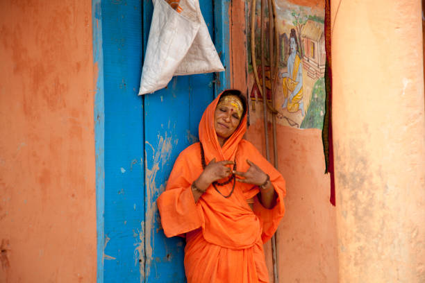 Hindu woman  with hands affected by leprosy out her home in Varanasi Varanasi - November 1,2016:  Hindu woman  with hands affected by leprosy out her home in Varanasi. This is one of the oldest inhabited cities in the world and also the holiest of the seven sacred cities in Hinduism and Jainism and so the most important pilgrimage place for hindus. Many ascetics in Varanasi like the one in the picture stay in visible places in the ghats decorated with images of the hindu gods to attract the attention and donations of pilgrims and tourists. leprosy stock pictures, royalty-free photos & images