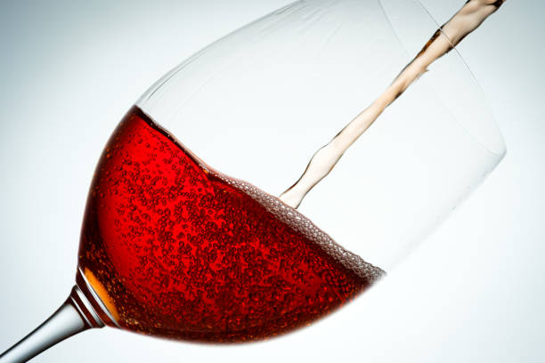 istock Red wine pouring in a glass in back lit close-up 1214075150