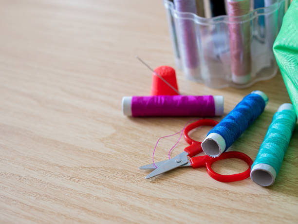 istock Spools of thread, bobbin, scissors and sewing accessories on a wooden background with shallow deep of field 1214075453