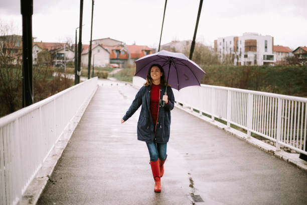 istock Young woman enjoying in rain 1214075895