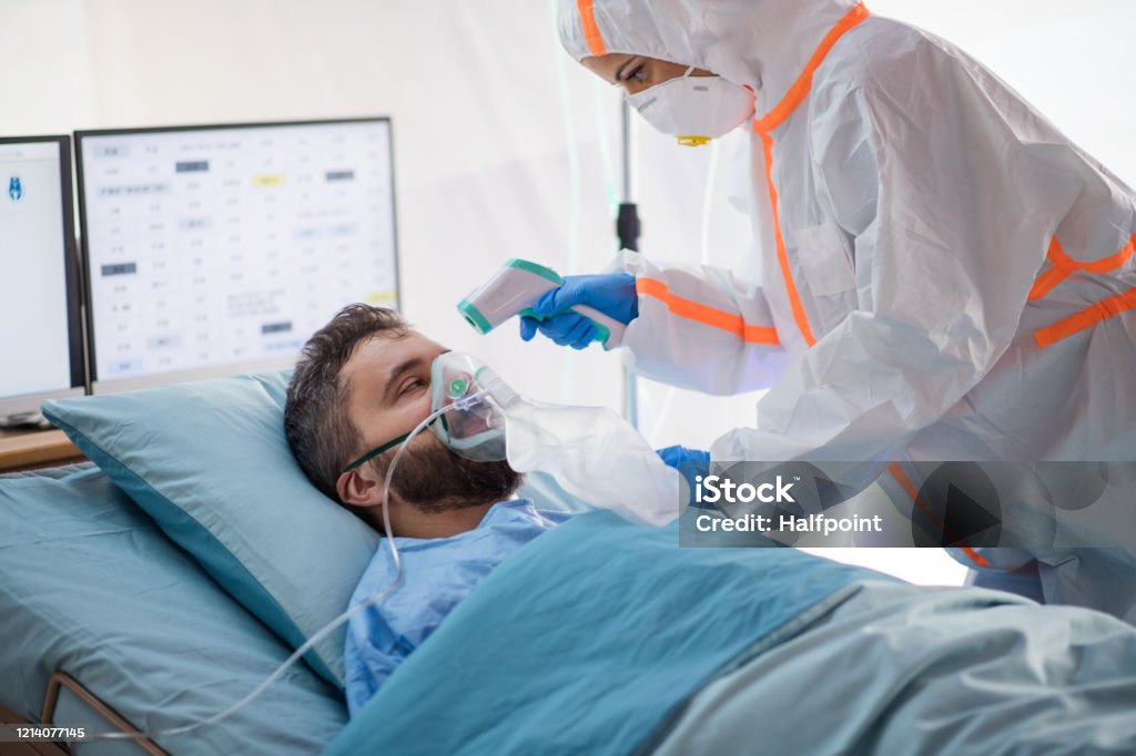 Infected patient in quarantine lying in bed in hospital, coronavirus concept. An infected patient in quarantine lying in bed in hospital, coronavirus concept. Doctor Stock Photo