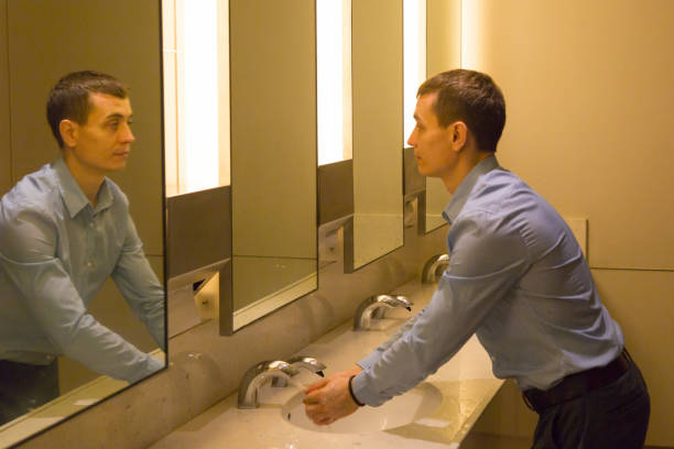 istock A man washes his hands in a public toilet. 1214078347