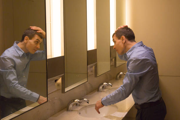 istock A man tidies his hair on his head. 1214078376