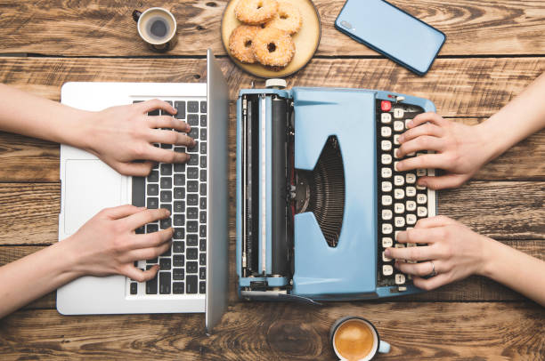 praca na laptopie i starej maszynie do pisania - machine typewriter human hand typing zdjęcia i obrazy z banku zdjęć