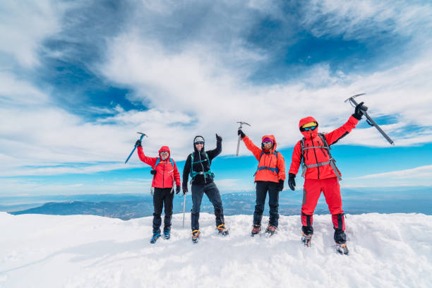equipe de escalada alpina está segurando machado de gelo e polegares para cima no pico da montanha de alta altitude no inverno - ice axe - fotografias e filmes do acervo