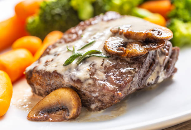 сочный стейк из говяжьего ребра с грибным соусом и детским овощем - steak filet mignon beef tenderloin стоковые фото и изображения