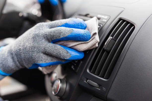 istock Car wash worker maintaining and detailing car interior console shine by using microfiber cloth. Cleaning salon concept. 1214082812