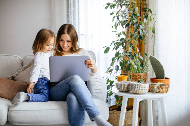 istock Happy laughing mother and daughter using laptop 1214083059