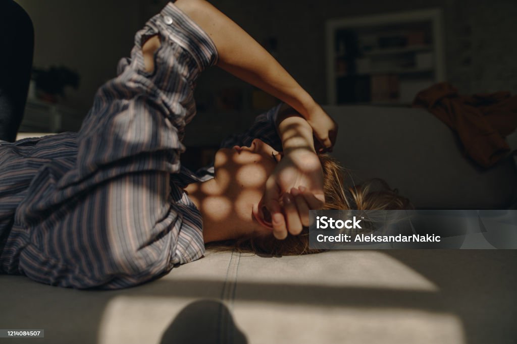First morning sunlight in my home Photo of a young woman coping with loneliness and isolation during CoVid 19 outbreak 30-39 Years Stock Photo