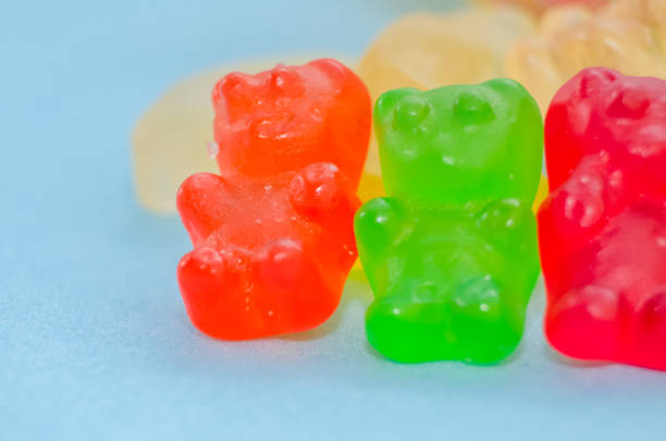 istock Two marmalade bears stand among other marmalade bears on a blue background, macro 1214085818