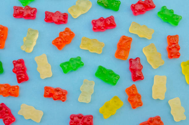 istock Delicious bright colored jelly bears on a blue background laid out in the same order, top view 1214085887