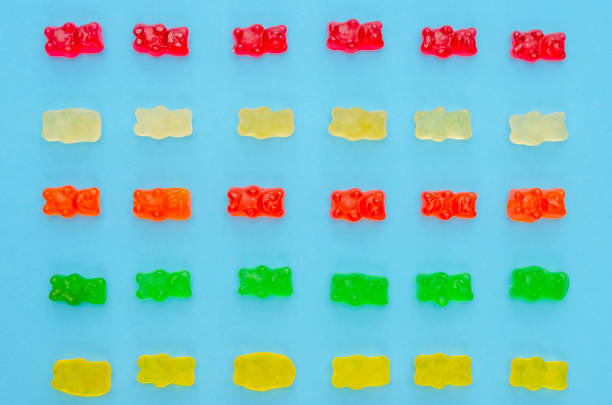 istock Delicious bright colored jelly bears on a blue background laid out in the same order, top view 1214086018