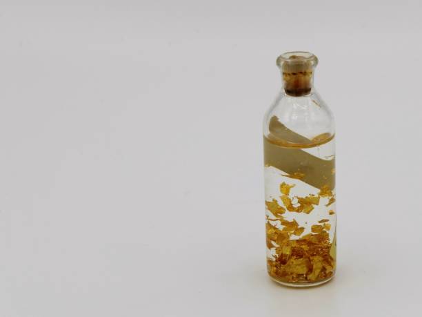 istock Small bottle with floating gold flakes 1214086161
