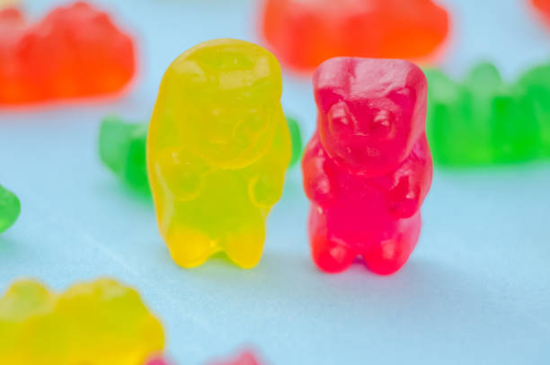 istock Two marmalade bears stand among other marmalade bears on a blue background, macro 1214086693