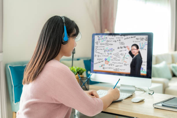 istock Asian woman student video conference e-learning with teacher on computer in living room at home. E-learning ,online ,education and internet social distancing protect from COVID-19 viruses. 1214087269