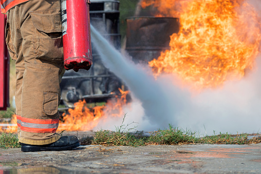 Firefighter using a carbon dioxide extinguisher to fight a fire.