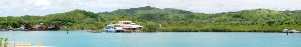 The panoramic view of Mahogany Bay with partially sunken ship and ferry boat terminal on Roatan Island (Honduras).