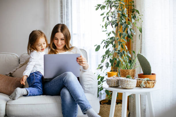 istock Happy laughing mother and daughter using laptop 1214089450
