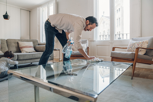 Man cleaning table on living room