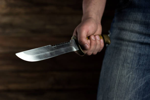 istock man stands menacingly with a knife, close-up 1214093858