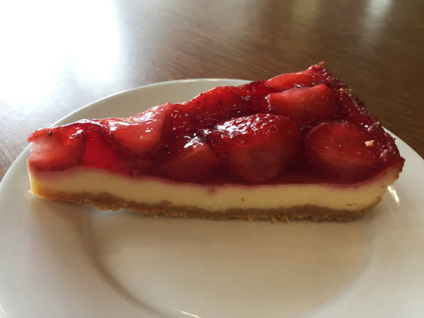istock Slice of cheesecake with strawberries on a white plate. 1214094376
