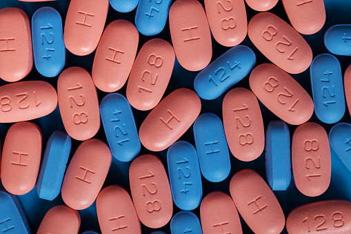 HIV/AIDS therapy pills on pink background