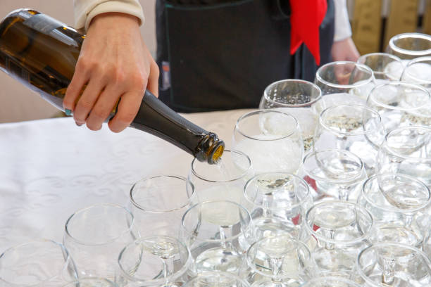 istock The waiter pours champagne into the glasses 1214095771